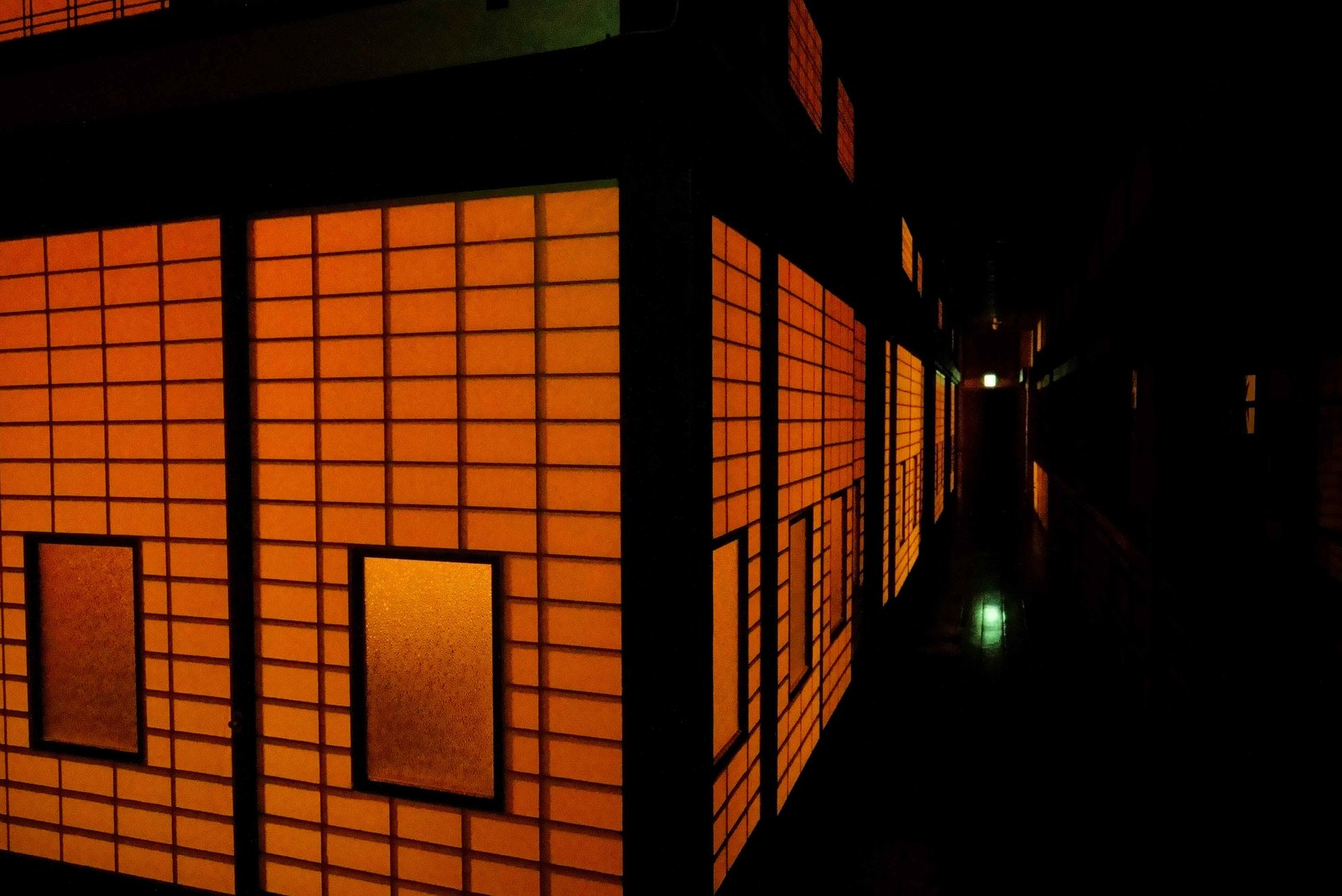 Paper screens glowing from within, along the old wooden corridor